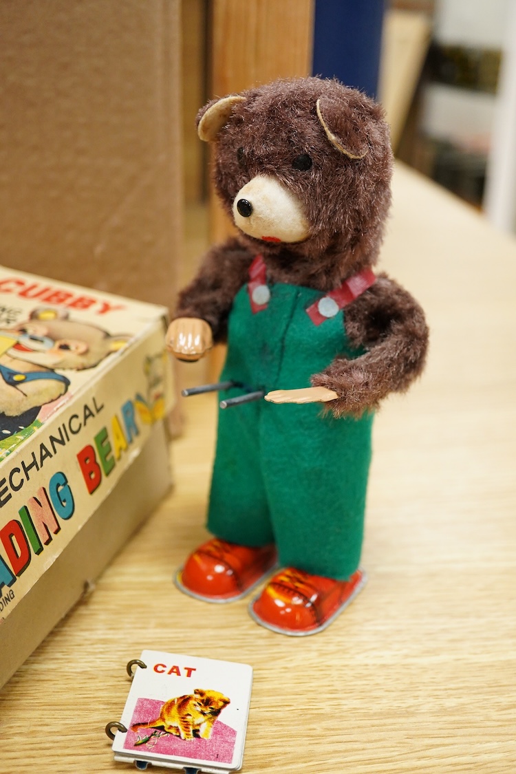 Three boxed clockwork tinplate toys - a 1960s Japanese Cubby the Reading Bear, by Alps (Japan), 17cm high, a USSR doll, and a later ‘Roli Zoli’ clown on a scooter (3)